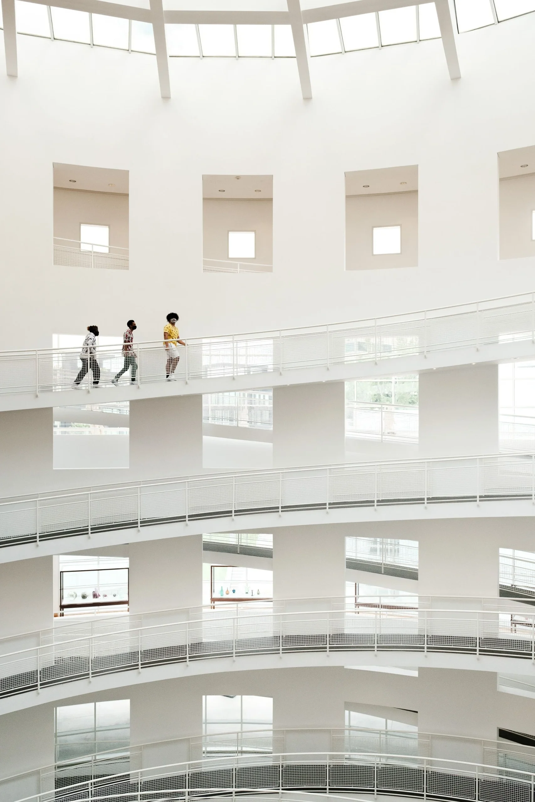 Visitors moving through a bright art museum with white walls